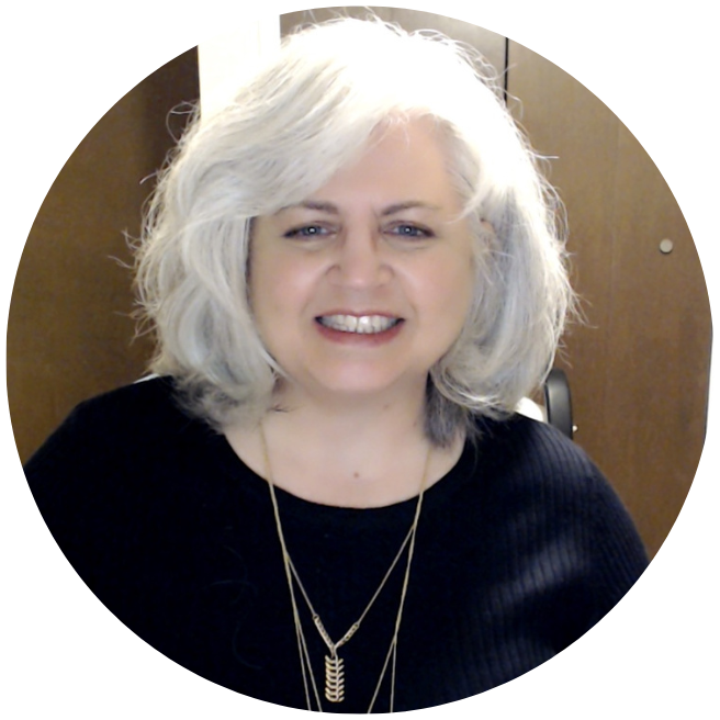 a woman with gray hair smiling in front of a camera.